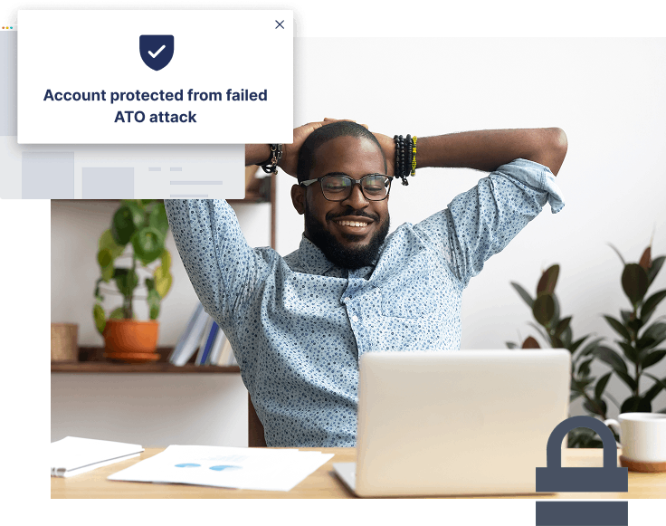 A man sits relaxed at a desk with a laptop, while a popup message reads, "Account protected from failed ATO attack—stop more ATOs effortlessly.